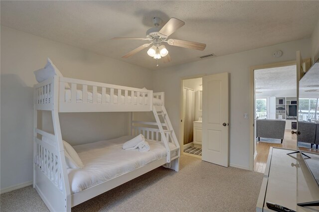 bedroom featuring baseboards, light carpet, a ceiling fan, and visible vents
