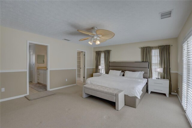 bedroom with a walk in closet, carpet flooring, and visible vents