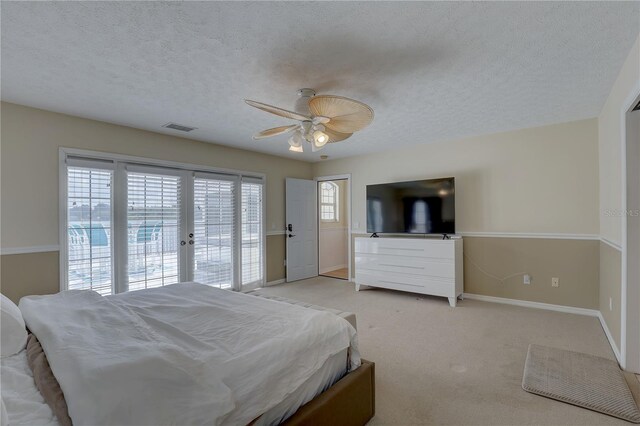 bedroom featuring a textured ceiling, visible vents, baseboards, access to outside, and light carpet