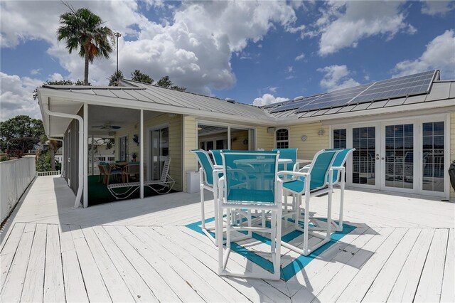wooden deck with french doors, outdoor dining area, and ceiling fan