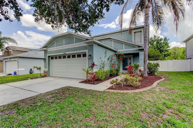view of front of property featuring a garage, fence, a front lawn, concrete driveway, and stucco siding
