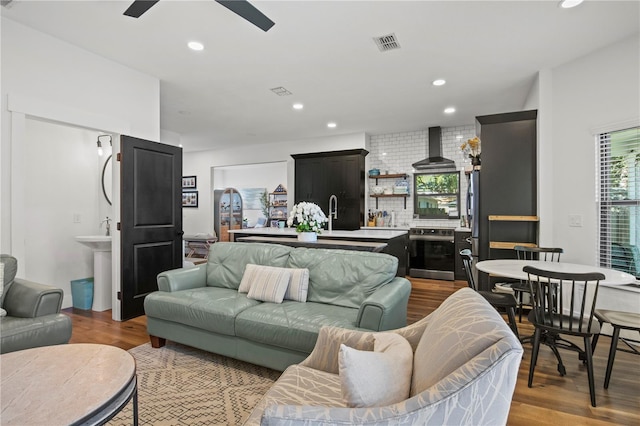 living area with recessed lighting, ceiling fan, wood finished floors, and visible vents
