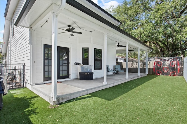 rear view of property featuring a patio, a fenced backyard, ceiling fan, and a yard