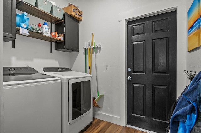 washroom featuring cabinet space, baseboards, dark wood finished floors, and washing machine and dryer