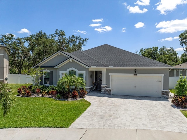 view of front of property with stucco siding, a garage, a front lawn, and decorative driveway