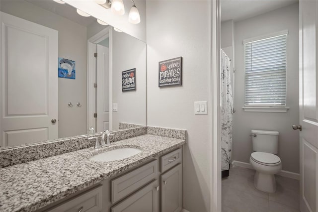 full bathroom with toilet, baseboards, tile patterned floors, and vanity
