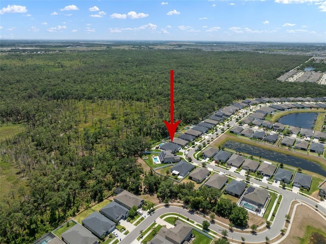 drone / aerial view featuring a residential view and a view of trees