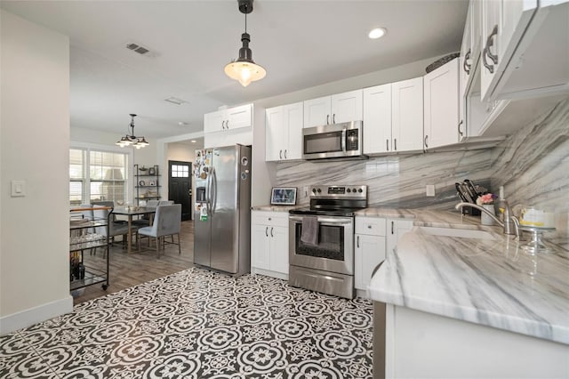 kitchen with white cabinetry, appliances with stainless steel finishes, and tasteful backsplash