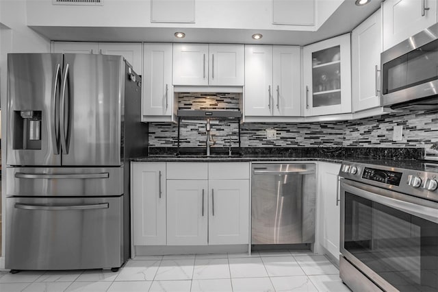 30 Turner St Unit 202, Clearwater, FL 33756 - kitchen with stainless steel appliances, light marble finish floors, dark stone counters, white cabinets, and glass insert cabinets