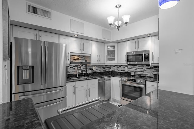 30 Turner St Unit 202, Clearwater, FL 33756 - kitchen featuring appliances with stainless steel finishes, a sink, white cabinets, tasteful backsplash, and a chandelier