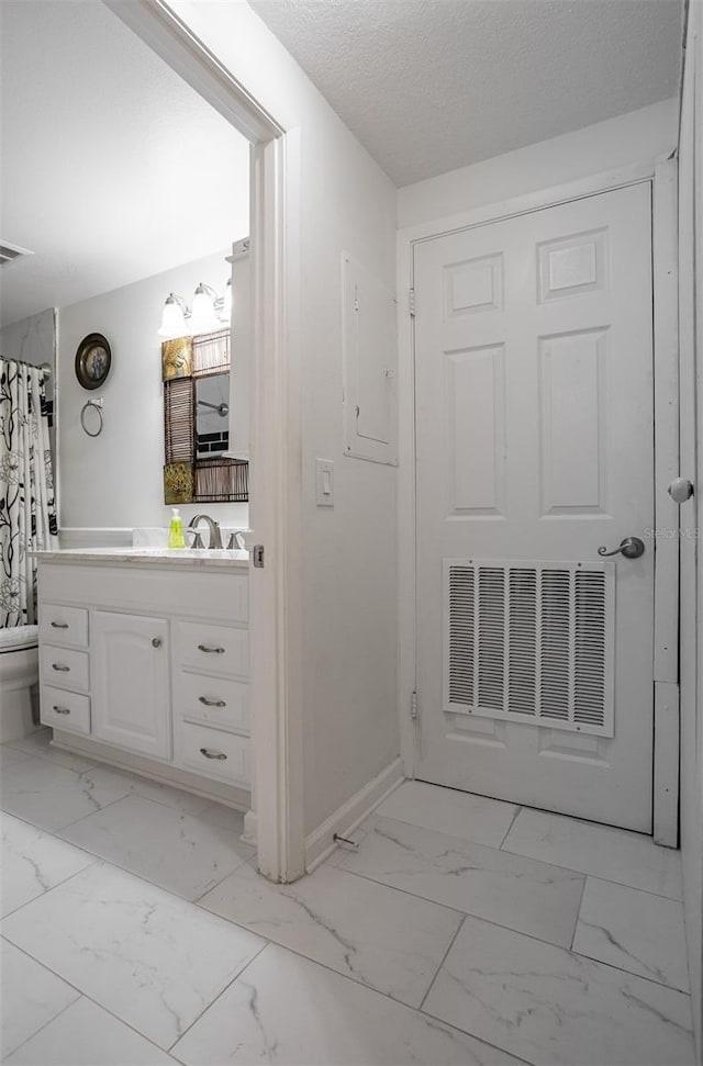 30 Turner St Unit 202, Clearwater, FL 33756 - full bath featuring marble finish floors, vanity, toilet, baseboards, and a textured ceiling