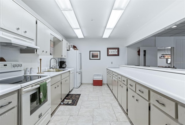 30 Turner St Unit 202, Clearwater, FL 33756 - kitchen with white appliances, a sink, under cabinet range hood, light countertops, and baseboards
