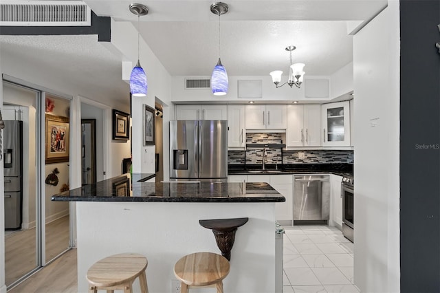 30 Turner St Unit 202, Clearwater, FL 33756 - kitchen featuring appliances with stainless steel finishes, white cabinets, a center island, decorative backsplash, and a sink