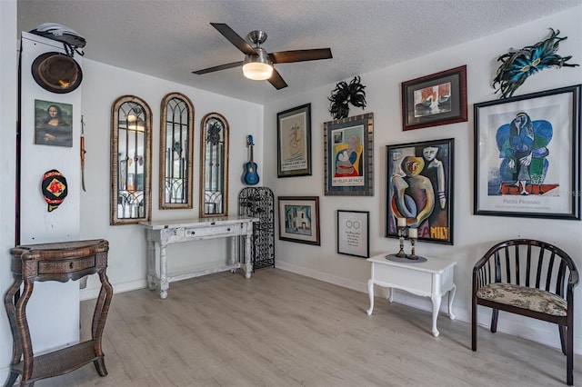 30 Turner St Unit 202, Clearwater, FL 33756 - sitting room featuring light wood-type flooring, a textured ceiling, ceiling fan, and baseboards