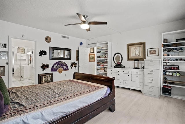 30 Turner St Unit 202, Clearwater, FL 33756 - bedroom featuring a walk in closet, light wood-type flooring, ceiling fan, a closet, and ensuite bath