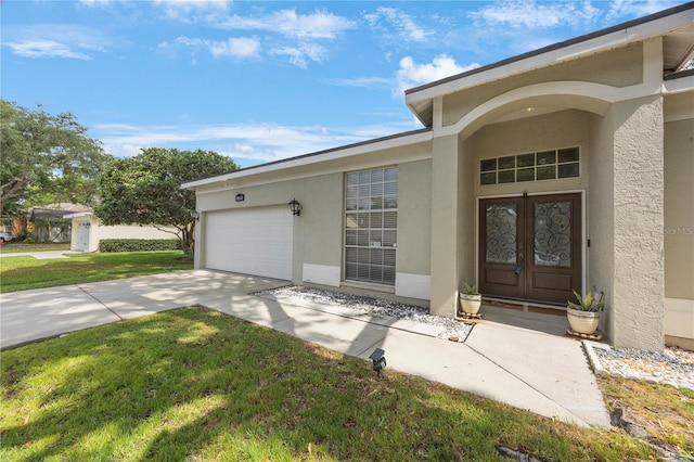 18520 Ambly Ln, Tampa, FL 33647 - entrance to property featuring stucco siding, a garage, driveway, and french doors