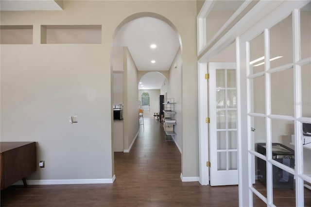 18520 Ambly Ln, Tampa, FL 33647 - hallway featuring arched walkways, dark wood-type flooring, and baseboards