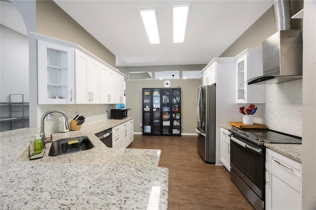 18520 Ambly Ln, Tampa, FL 33647 - kitchen with stainless steel appliances, a sink, white cabinetry, decorative backsplash, and wall chimney exhaust hood