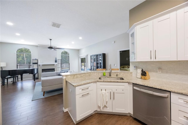 18520 Ambly Ln, Tampa, FL 33647 - kitchen with stainless steel dishwasher, a sink, a peninsula, dark wood-type flooring, and backsplash