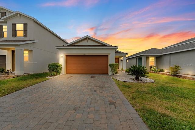 11819 Brighton Knoll Loop, Riverview, FL 33579 - view of front facade with decorative driveway, a yard, stucco siding, and a garage