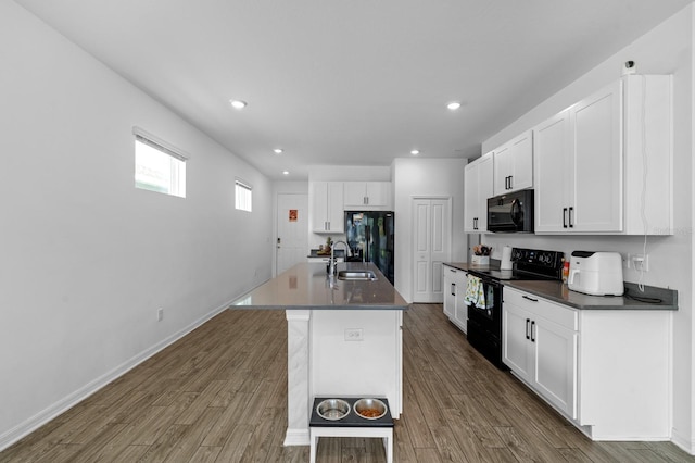 11819 Brighton Knoll Loop, Riverview, FL 33579 - kitchen with black appliances, a sink, dark countertops, white cabinets, and dark wood-style flooring