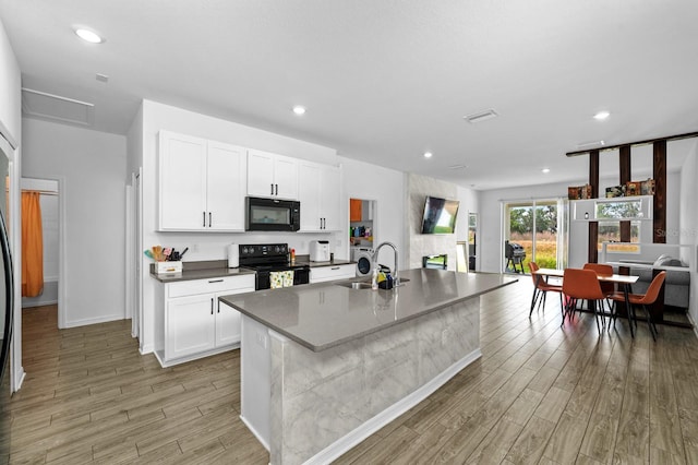 11819 Brighton Knoll Loop, Riverview, FL 33579 - kitchen featuring black appliances, a sink, light wood-type flooring, white cabinets, and recessed lighting