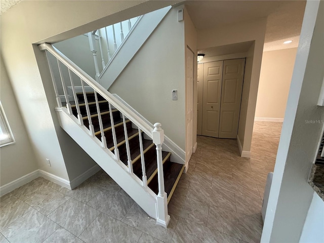 staircase featuring baseboards