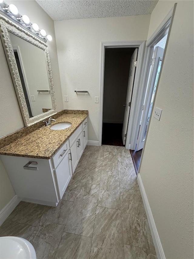 bathroom featuring vanity, baseboards, and marble finish floor