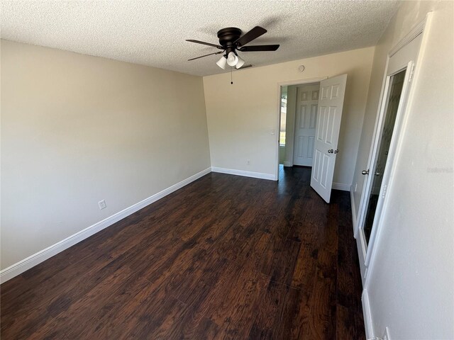 unfurnished bedroom with baseboards, a textured ceiling, dark wood-style flooring, and a ceiling fan