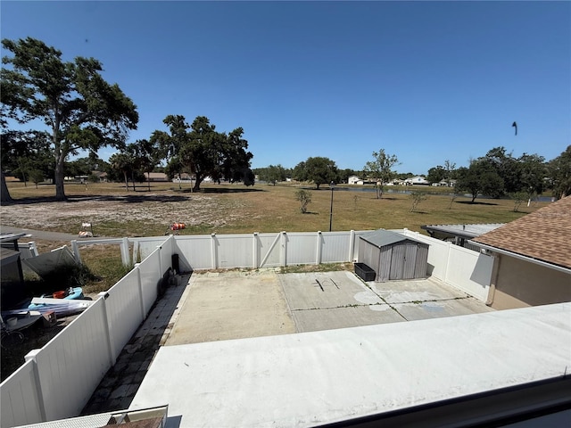 exterior space featuring a fenced backyard, an outbuilding, a patio area, and a storage shed