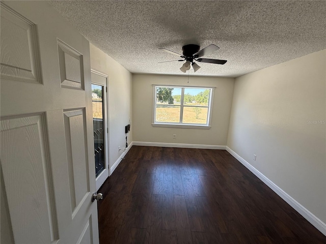 unfurnished room featuring baseboards, ceiling fan, dark wood finished floors, and a textured ceiling