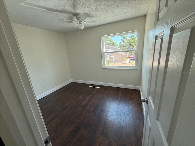 empty room with baseboards, ceiling fan, wood-type flooring, and a textured ceiling