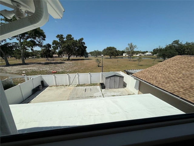 details featuring a flat roof, a fenced backyard, and a shingled roof