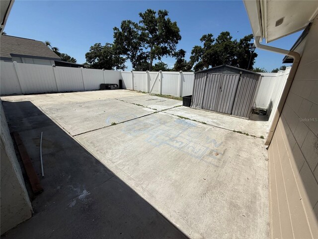 view of patio featuring a fenced backyard, an outbuilding, and a storage shed