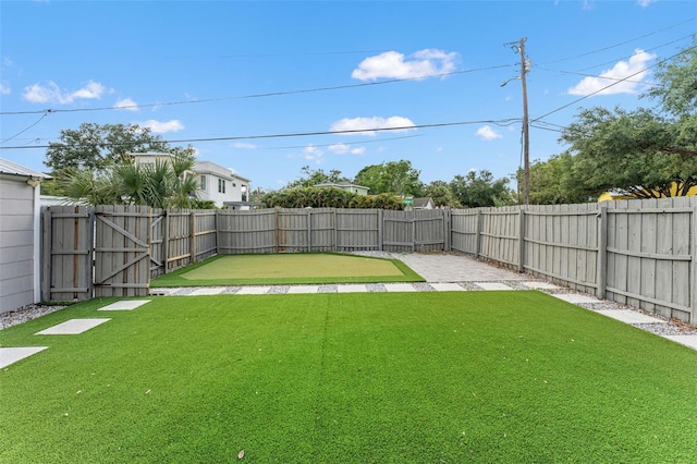 view of yard with a fenced backyard and a gate