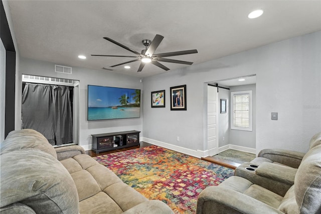 living room featuring a barn door, recessed lighting, a ceiling fan, baseboards, and visible vents