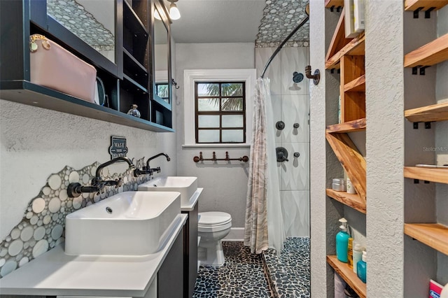 bathroom featuring vanity, toilet, and tiled shower