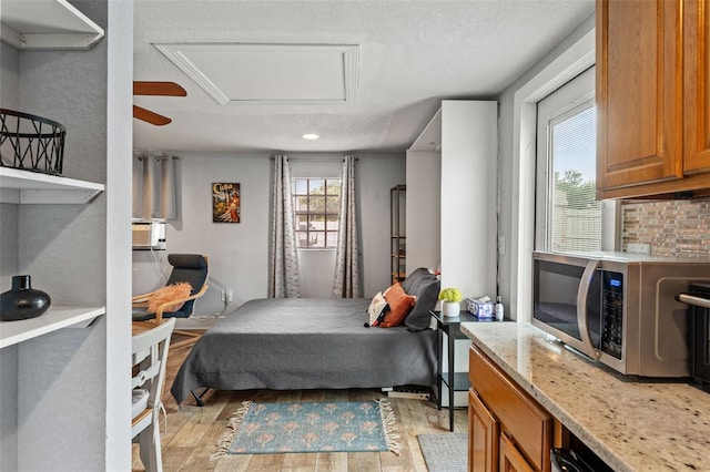 bedroom featuring a textured ceiling, recessed lighting, and light wood-style flooring