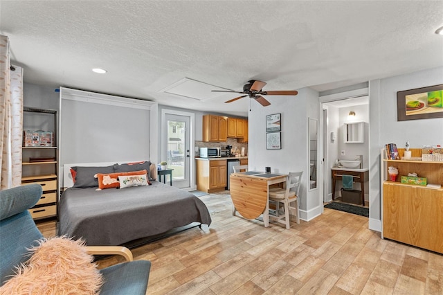 bedroom featuring connected bathroom, light wood finished floors, a textured ceiling, recessed lighting, and baseboards