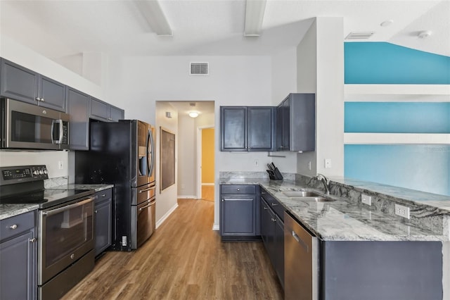 kitchen with light stone countertops, a sink, stainless steel appliances, dark wood-type flooring, and visible vents