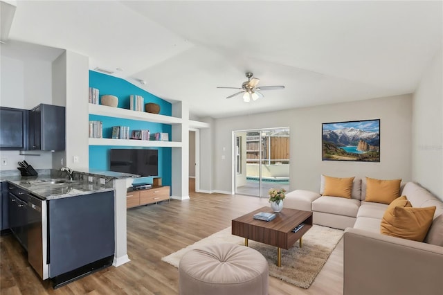 living area featuring built in shelves, a ceiling fan, baseboards, wood finished floors, and vaulted ceiling