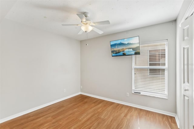 unfurnished room featuring baseboards, ceiling fan, and wood finished floors