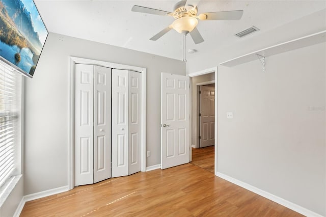 unfurnished bedroom with a ceiling fan, baseboards, light wood-type flooring, visible vents, and a closet