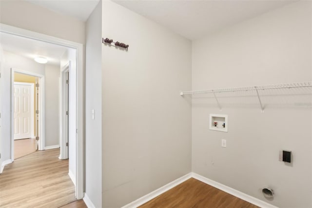 laundry room with laundry area, baseboards, wood finished floors, and washer hookup