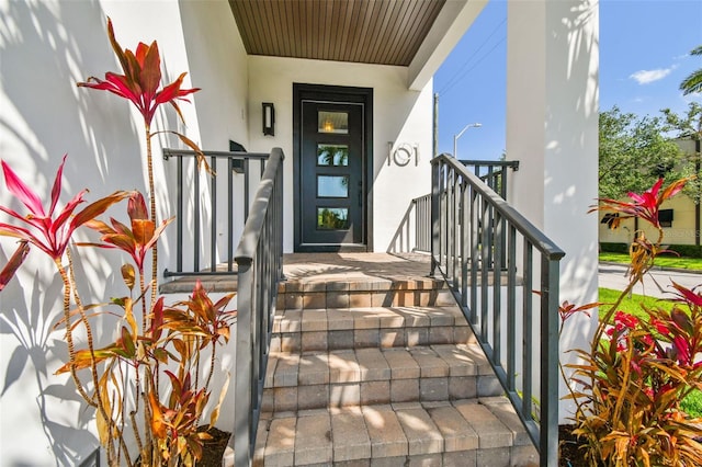 property entrance with stucco siding and a porch