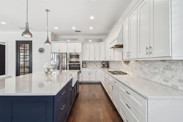 kitchen with blue cabinetry, tasteful backsplash, white cabinets, ornamental molding, and stainless steel appliances