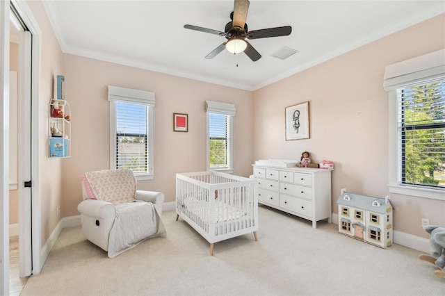 bedroom with light colored carpet, baseboards, crown molding, and a nursery area