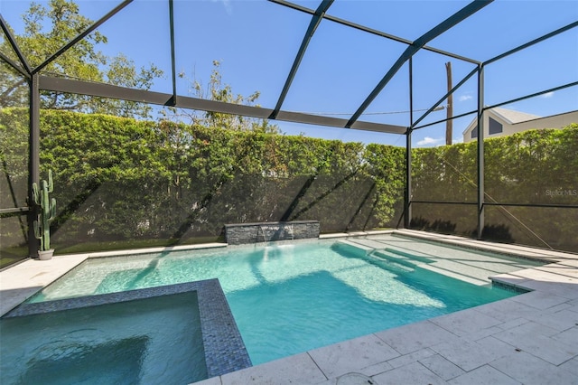 view of pool with glass enclosure, a pool with connected hot tub, and a patio area