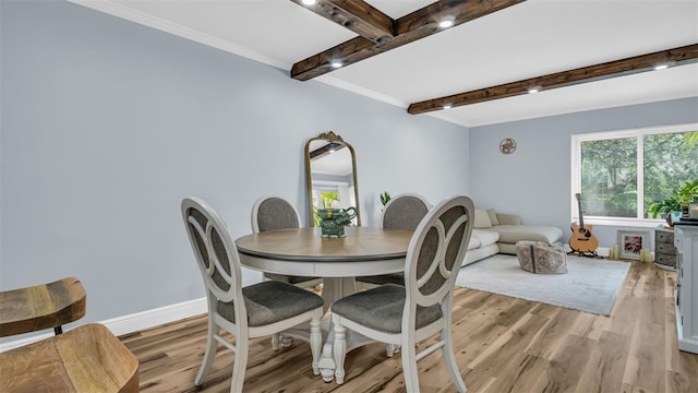 dining space with baseboards, ornamental molding, light wood-style flooring, and beam ceiling