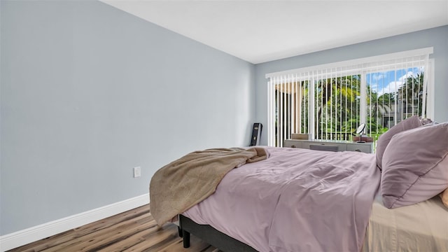 bedroom with baseboards and wood finished floors